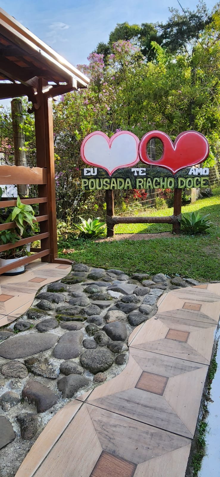 Placa de entrada da Pousada Riacho Doce com corações vermelhos